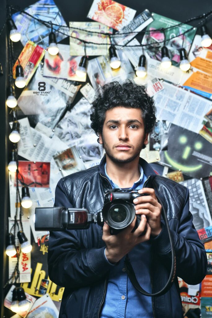 Photographer holding a camera, with artistic background lighting.