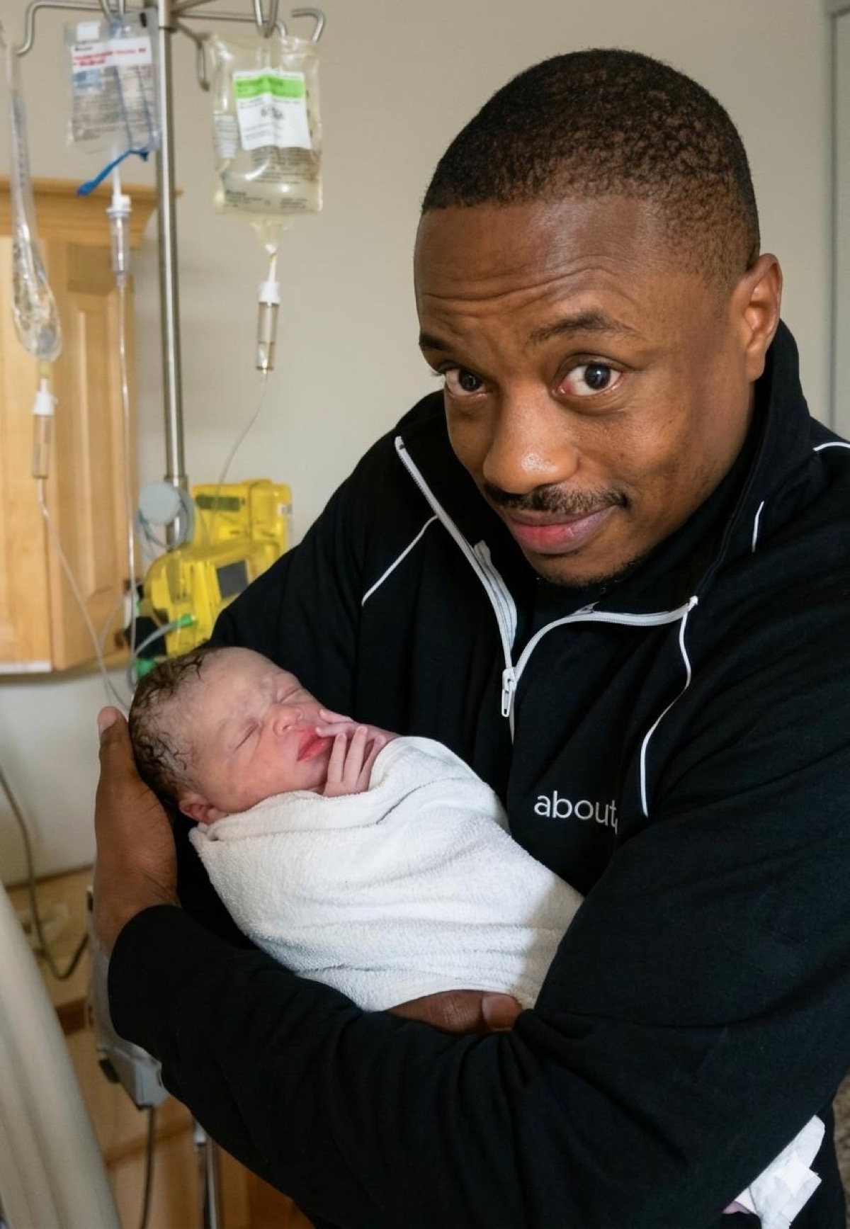 Frederick Van Johnson holding newborn Cameron, hospital